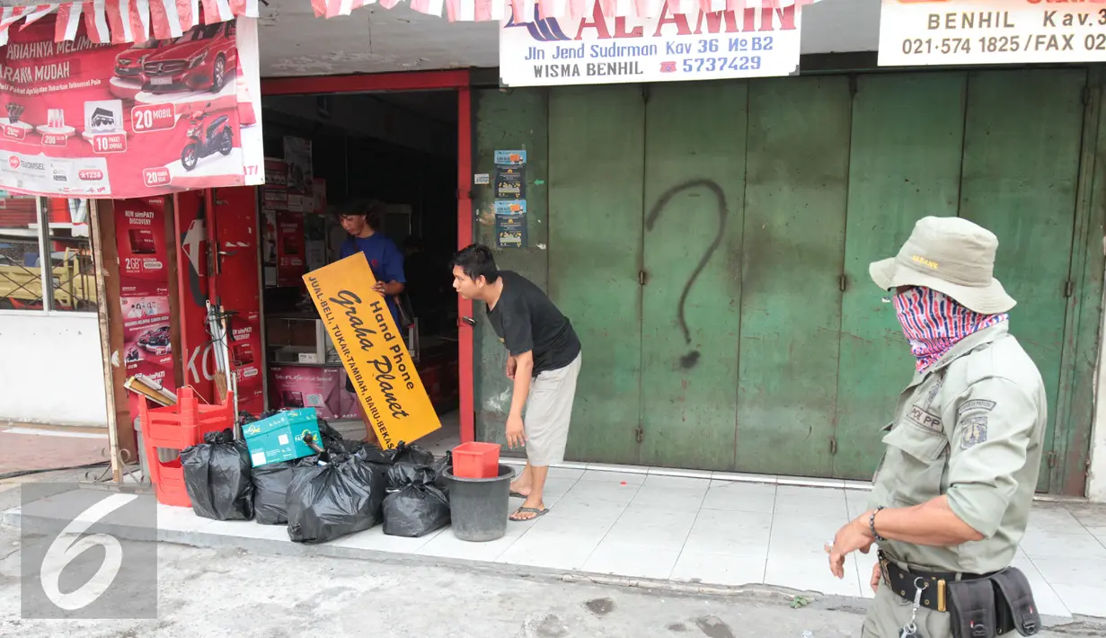 Dua orang warga tampak mengeluarkan barang-barangnya jelang pembogkaran 40 kios yang akan dilakukan oleh Satpol PP di Kavling 36 Pasar Benhil, Jakarta, (29/8/2015). (Liputan6.com/Gempur M Surya)