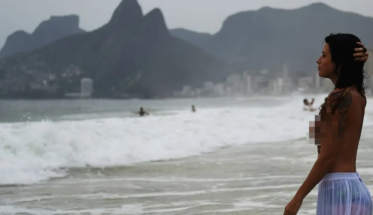 Seorang wanita dari kelompok gerakan topless ikut merayakan ritual Lemanja di Pantai Arpoador, Rio de Janeiro, Brasil, Senin (2/2/2015). (AFP Photo/Yasuyoshi Chiba)