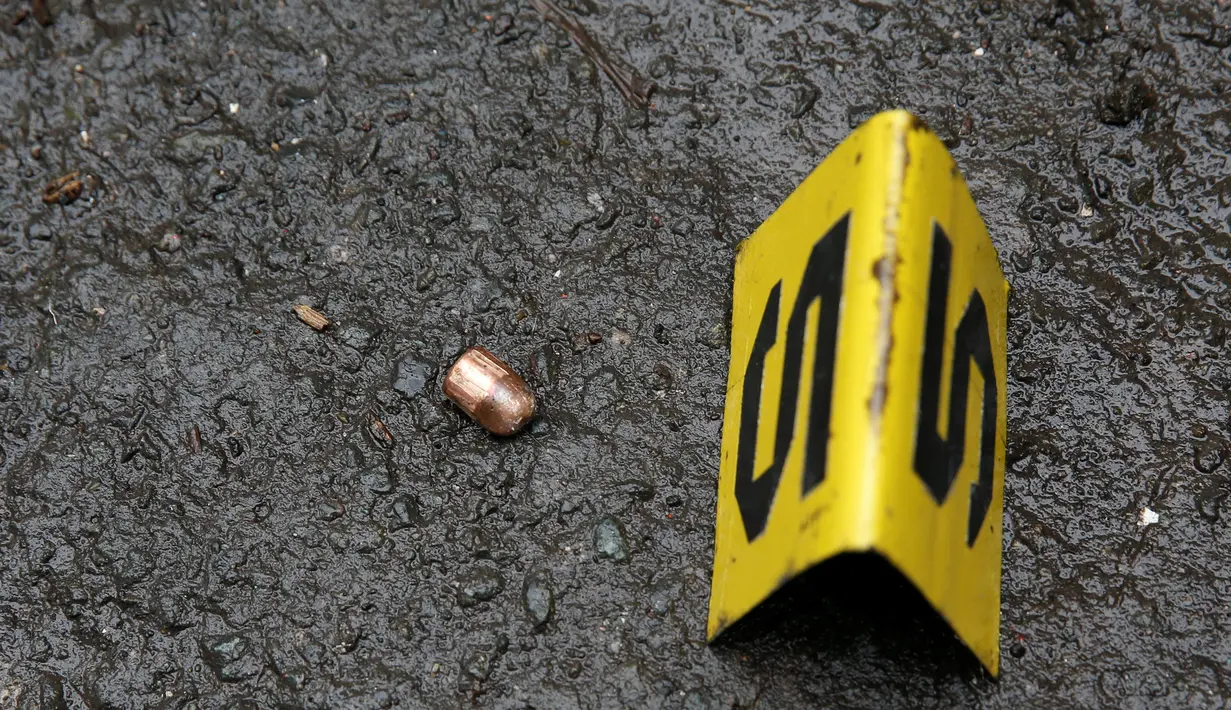 Barang bukti peluru dari penembak tak dikenal ditemukan di dekat mayat Nora Acielo yang tergeletak di Manila, Filipina, Kamis (8/12). Acielo ditembak saat sedang mengantarkan kedua anaknya berangkat sekolah. (REUTERS/Erik De Castro)