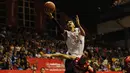 Pebasket Satria Muda Britama Jakarta, Gunawan (atas) melompat melewati hadangan pemain Stadium Jakarta di laga NBL Championship 2015, Sabtu (2/5/2015). Satria Muda unggul tipis 61-59 atas Stadium Jakarta. (Liputan6.com/Helmi Fithriansyah)
