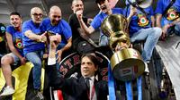 Pelatih Inter Milan Simone Inzaghi memegang trofi saat merayakan dengan para penggemar setelah Inter Milan memenangkan pertandingan final Coppa Italia 2021/2022 4-2 atas Juventus di Stadion Olimpico, Roma, Kamis (12/5/2022) dini hari WIB. Bagi Inter Milan, ini gelar juara Coppa Italia 2021/2022 kedelapan setelah sebelumnya sukses menjadi kampiun turnamen ini pada 1939, 1978, 1982, 2005, 2006, 2010, dan 2011. (Isabella BONOTTO / AFP)