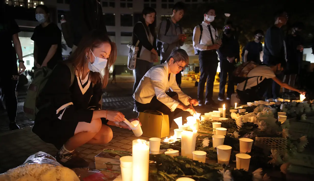 Para pengunjuk rasa menyalakan lilin untuk memberi penghormatan kepada mahasiswa Alex Chow Tsz-lok di Hong Kong (8/11/2019). Alex Chow Tsz-lok, 22 tahun, merupakan mahasiswa ilmu komputer dari mahasiswa Hong Kong University of Science and Technology. (AP Photo/Kin Cheung)