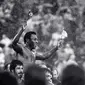 Pemain sepak bola Brasil Edson Arantes do Nascimento atau Pele mengibarkan bendera Brasil dan AS saat dibawa keluar lapangan setelah pertandingan terakhirnya di Stadion Giants, East Rutherford, New Jersey, Amerika Serikat, 1 Oktober 1977. Pada akhir 1970-an, Pele bermain di Amerika Serikat untuk New York Cosmos sebelum akhirnya pensiun pada 1977. (AP Photo/Richard Drew, File)