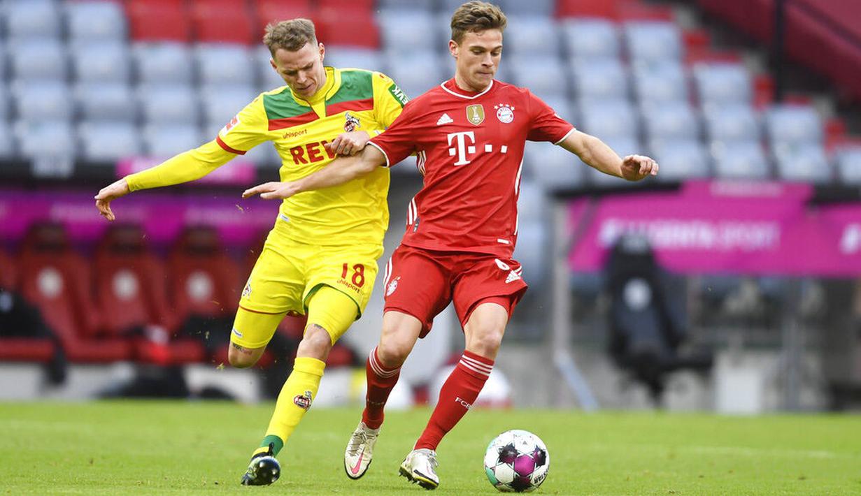 Pemain Bayern Munchen, Joshua Kimmich, berebut bola dengan pemain FC Koln, Ondrej Duda, pada laga Bundesliga di Stadion Allianz, Minggu (27/2/2021). Bayern menang dengan skor 5-1. (AP/Andreas Schaad)