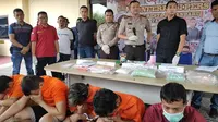 Tersangka narkoba jenis pil ekstasi dan sabu dihadirkan bersama barang bukti haramnya di Polresta Pekanbaru. (Liputan6.com/M Syukur)