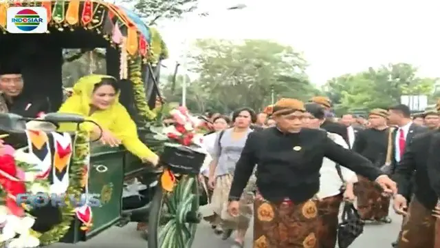 Ibu Iriana Joko Widodo juga ikut membagikan bingkisan untuk masyarakat. Sementara Kaesang sibuk dengan kameranya.