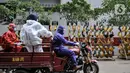 Rizky (33) bersama rekan Tim Sterilisasi menggunakan sepeda motor saat mengangkut sepatu tenaga kesehatan yang bertugas menangani pasien Covid-19 untuk dicuci di Rumah Sakit Darurat (RSD) Wisma Atlet Kemayoran, Jakarta. (merdeka.com/Iqbal Nugroho)