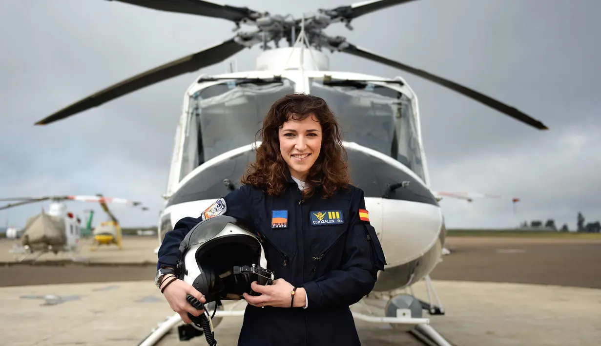 Carla Rozalen, 29 tahun berpose di depan helikopter utilitas bermesin ganda Bell 412 di FAASA Group di Palma del Rio, Cordoba (27/2). Carla merupakan satu-satunya pilot wanita Grup Faasa dan bekerja menangani kebakaran hutan.  (AFP Photo/Cristina Quicler)