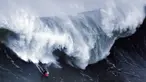 Seorang peselancar bersiap menyambut kejaran ombak besar dibelakangnya saat berselancar di Praia do Norte di Nazare, Portugal (19/11). Selancar merupakan sebuah olahraga yang dilakukan di atas ombak yang tinggi. (AFP/Patricia De Melo Moreira)