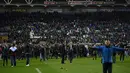 Laga Wigan Athletic Vs Manchester City pada babak kelima Piala FA berujung pada kerusuhan suporter di Stadion DW, Senin (19/2). Begitu peluit akhir dibunyikan wasit, suporter Manchester City melemparkan berbagai benda ke arah lapangan. (Oli SCARFF/AFP)
