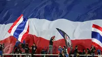 Suporter Timnas Thailand membentangkan bendera raksasa saat menyambut kemenangan timnya atas Indonesia di National Stadium Rajamangala, Bangkok, Sabtu (17/12). Thailand berhasil meraih piala AFF untuk yang kelima kali. (Liputan6.com/Helmi Fithriansyah)