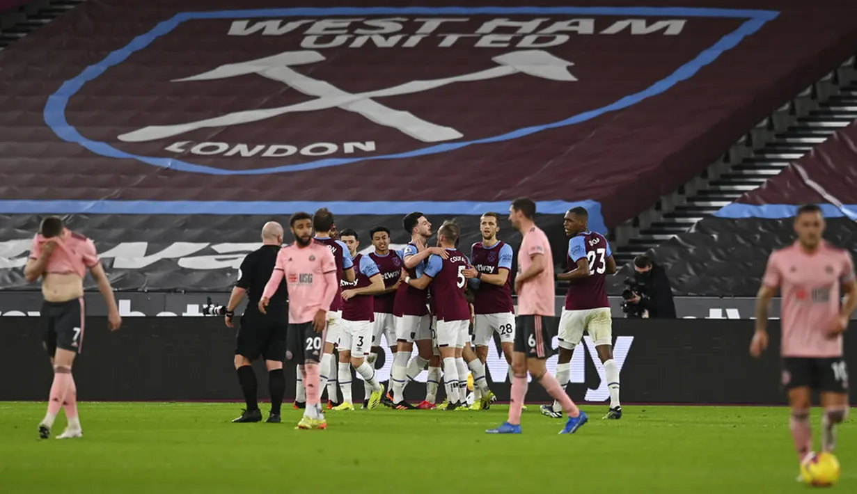 Pemain West Ham United Declan Rice (tengah) merayakan dengan rekan satu tim usai mencetak gol ke gawang Sheffield United pada pertandingan Liga Inggris di London Stadium, London, Inggris, Senin (15/2/2021). West Ham United menang 3-0. (Glyn Kirk/Pool via AP)