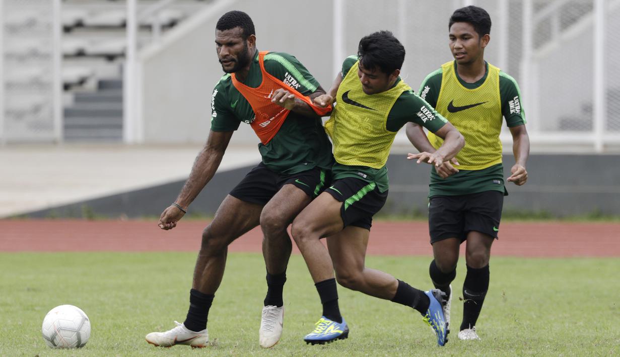Pemain Timnas Indonesia U-22, Marinus Wanewar, berebut bola dengan Asnawi Mangkualam saat latihan di Stadion Madya, Jakarta, Jumat (18/1). Latihan ini merupakan persiapan jelang Piala AFF U-22. (Bola.com/Yoppy Renato)