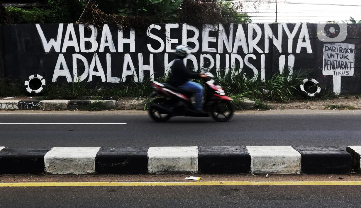 Pengendara melintas di depan mural yang berisi kritikan di Jalan Raya Bogor, Depok, Jawa Barat, Minggu (19/9/2021). Kritik terhadap pemerintah lewat coretan dinding atau mural sempat menjadi polemik karena dihapus. (Liputan6.com/Helmi Fithriansyah)