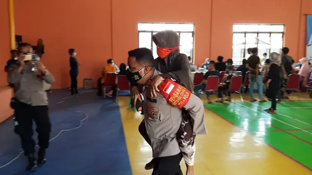 Kapolsek Tarumajaya Edy Suprayitno menggendong nenek Emah yang berusia 78 tahun ke lokasi vaksinasi Covid-19 di Bekasi.