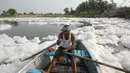 Seorang pria menaiki sampan di Sungai Yamuna yang tercemar di New Delhi, Sabtu (8/7). Sungai Yamuna sangat penting bagi masyarakat India karena banyak perayaan yang dilakukan di sungai tersebut. (DOMINIQUE FAGET / AFP)