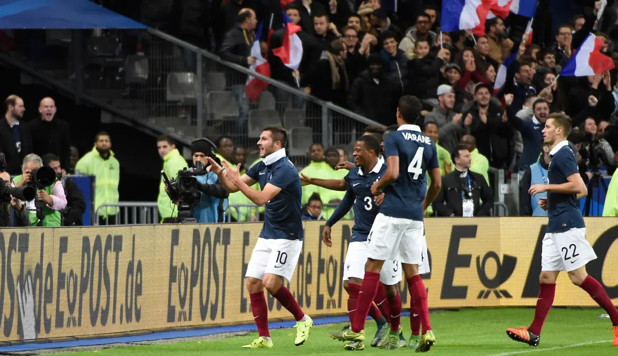 Penyerang Perancis, Andre-Pierre Gignac (kiri) melakukan selebrasi usai mencetak gol kegawang Perancis ada laga persahabatan di stadion Stade de France, Perancis, (13/11). Perancis menang atas Jerman dengan skor 2-0. (AFP PHOTO/MIGUEL MEDINA)