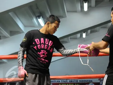  Petinju Indonesia, Daud Yordan melepas sarung tinju usai latihan di sasana Pertina, Jakarta, Rabu (3/2/2016). Daud akan melawan Yoshitaka Kato dalam laga kelas ringan WBO "Road to the World  Champions", Jumat (5/2). (Liputan6.com/Helmi Fithriansyah)