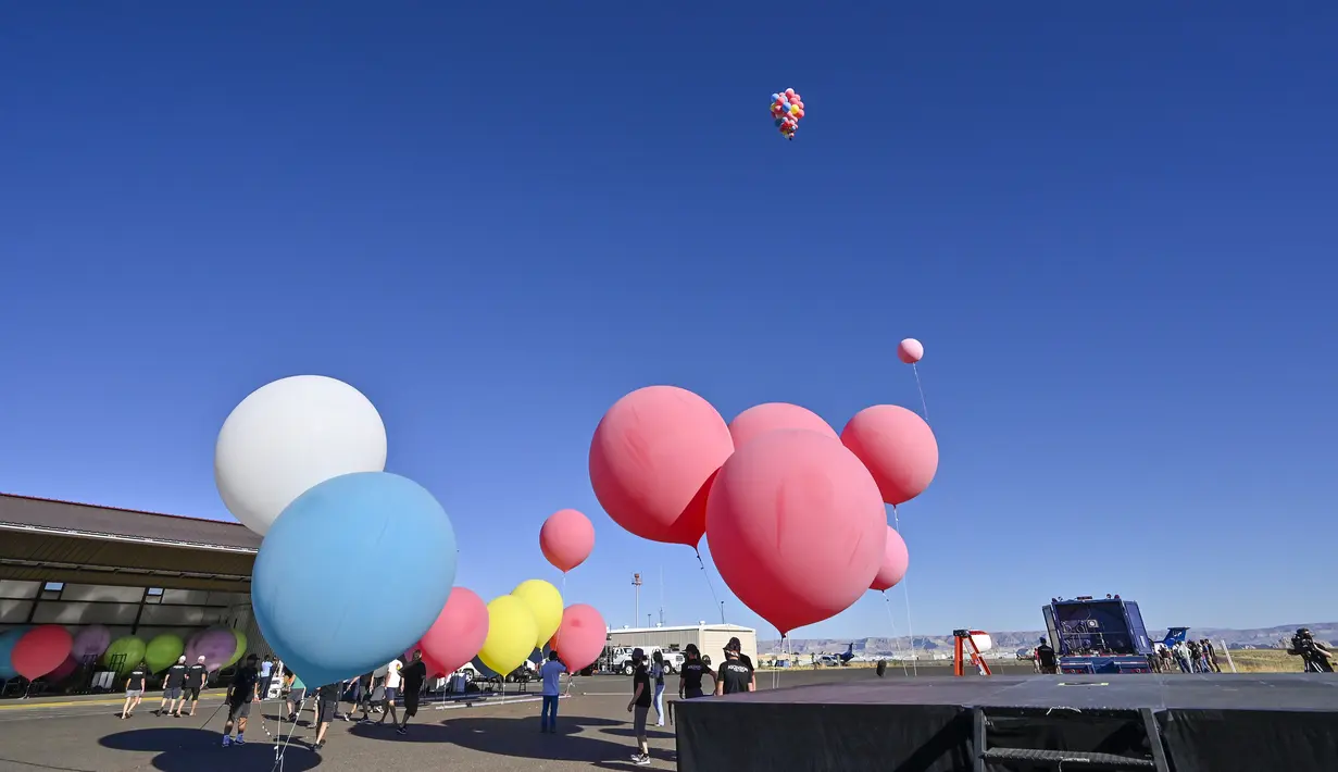 David Blaine terbang dengan memegang balon helium saat melakukan aksi "Ascension" di Page, Arizona, Amerika Serikat, Rabu (2/9/2020). Aksi tersebut mencetak rekor baru sebagai acara langsung YouTube Originals yang paling banyak ditonton. (David Becker/GETTY IMAGES NORTH AMERICA/Getty Images via AFP)