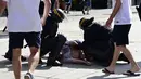 Polisi memeriksa kondisi seorang pria yang menjadi korban bentrok di kota Marseille, Prancis (11/6/2016). Bentrok terjadi menjelang pertandingan sepak bola Euro 2016 antara Inggris dan Rusia. (AFP Photo/ Tobias Schwarz)