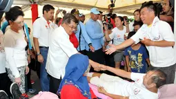Wakil Presiden Jusuf Kalla bersalaman dengan salah satu pendonor darah di Bundaran HI, Jakarta, Minggu (29/3/2015). Acara donor darah diadakan serentak di 25 kota di tanah air bertujuan membudayakan aksi donor darah. (Liputan6.com/Panji Diksana)