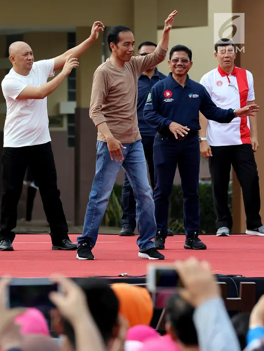 Presiden Joko Widodo (Jokowi) ditemani Koordinator Staf Khusus Presiden Teten Masduki memandu senam bersama di depan Kantor Wali Kota Tangerang, Minggu (4/11). Kegiatan itu dalam rangka perayaan Hari Kesehatan Nasional ke-54. (Liputan6.com/Johan Tallo)