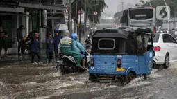 Sejumlah kendaraan melintasi genangan air di Jalan Medan Merdeka Timur, Jakarta, Jumat (24/1/2020). Hujan deras yang mengguyur Jakarta sejak pagi tadi mengakibatkan genangan air di Jalan Medan Merdeka Timur. (Liputan6.com/Faizal Fanani)