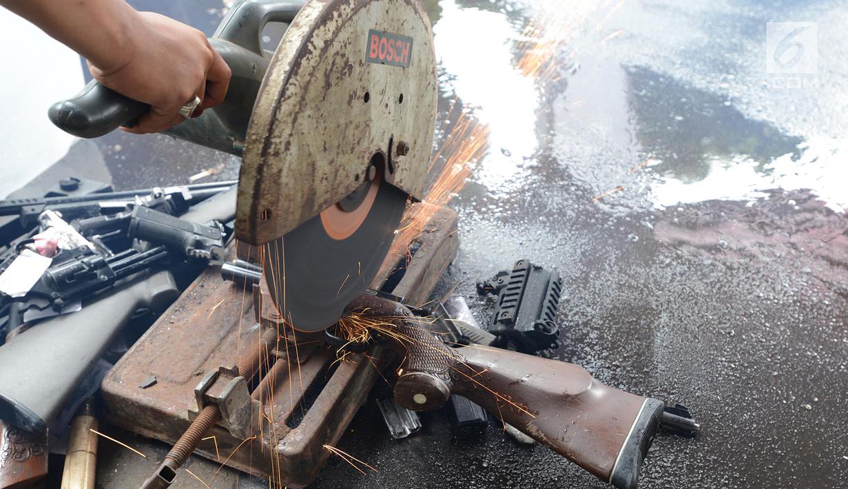 Senjata api dimusnahkan menggunakan mesin pemotong besi di Kejaksaan Negeri Jakarta Timur, Rabu (24/4). Barang bukti yang dimusnahkan berupa senjata api, senjata tajam dan beberapa jenis narkoba hasil pengungkapan kasus hukum di wilayah Jakarta Timur periode 2018-2019. (merdeka.com/Imam Buhori)