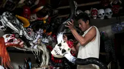 Seorang pria saat mewarnai topeng karakter mitologi Nikaragua dalam persiapan menyambut festival Los Aguizotes, Jumat (18/10/2015).  Festival ini dirayakan setiap tahunnya oleh warga Nikaragua. (REUTERS/Oswaldo Rivas)