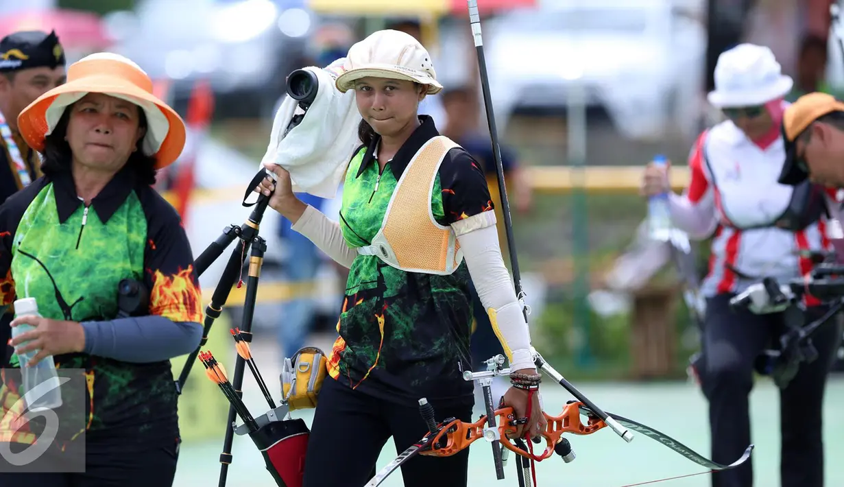 Pemanah Jatim, Eka Yuliana (tengah) meninggalkan area usai laga di kelas Recurve Women Individual di Lapangan Panahan Si Jalak Harupat, Kab Bandung, Rabu (21/9). Di final, Yuliana mengalahkan Rina D Puspitasari. (Liputan6.com/Helmi Fithriansyah)