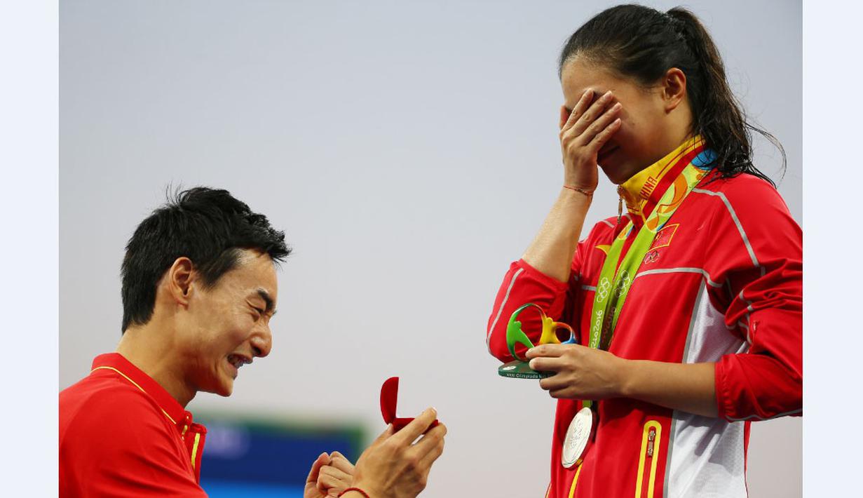 Peloncat indah China, Qin Kai (kiri), melamar kekasihnya yang juga peloncat indah China, He Zi, seusai acara pengalungan medali Olimpiade Rio 2016 di Maria Lenk Aquatics Centre, Rio de Janeiro, Brasil, (14/8/2016). (Reuters/Michael Dalder)
