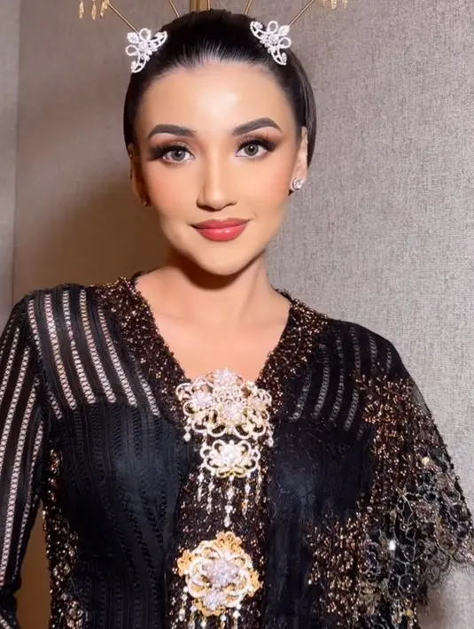 Wajahnya dipoles oleh MUA Juanda Hasid Sorumba dengan nuansa glam. Mengaplikasikan blush on pink dan lipstik glossy warna serasi. Riasan mata dibuat bold dengan eyeliner dan bulu mata serta eyeshadownya. [@bennusorumba]