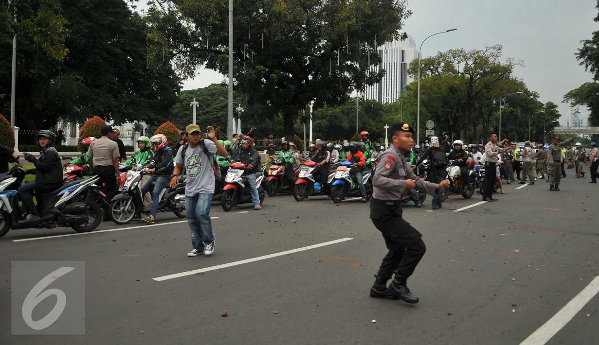Pengemudi ojek online dilempari batu oleh sopir taksi yang melakukan unjuk rasa di depan Istana Negara, Jakarta, Selasa (22/3). Aksi itu pecah saat pengunjuk rasa mendapat ejekan dari pengemudi ojek online. (Liputan6.com/Gempur M Surya)
