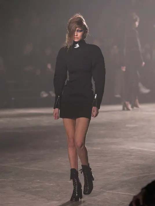 Model Gigi Hadid berjalan di atas catwalk saat mengenakan busana brand Versus Versace di atas panggung London Fashion Week di Inggris, (18/2). Gigi Hadid tampil dengan gaya urakan. (Foto oleh Joel Ryan / Invision / AP)