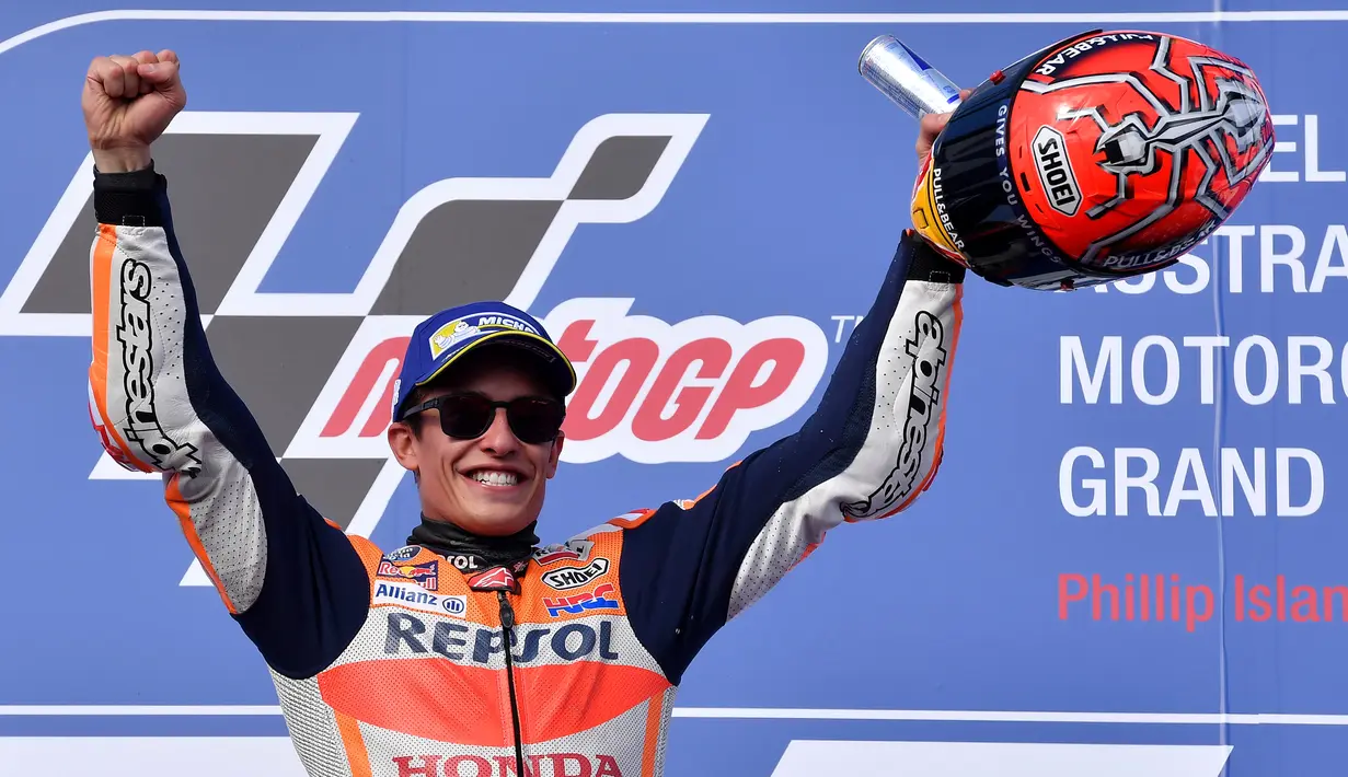Pembalap Repsol Honda, Marc Marquez merayakan kemenangannya diatas podium usai keluar sebagai juara MotoGP Australia di Phillip Island (22/10). Dalam MotoGP Australia ini tempat kedua diisi Rossi dan ketiga menjadi milik Vinales. (AP Photo/Andy Brownbill)