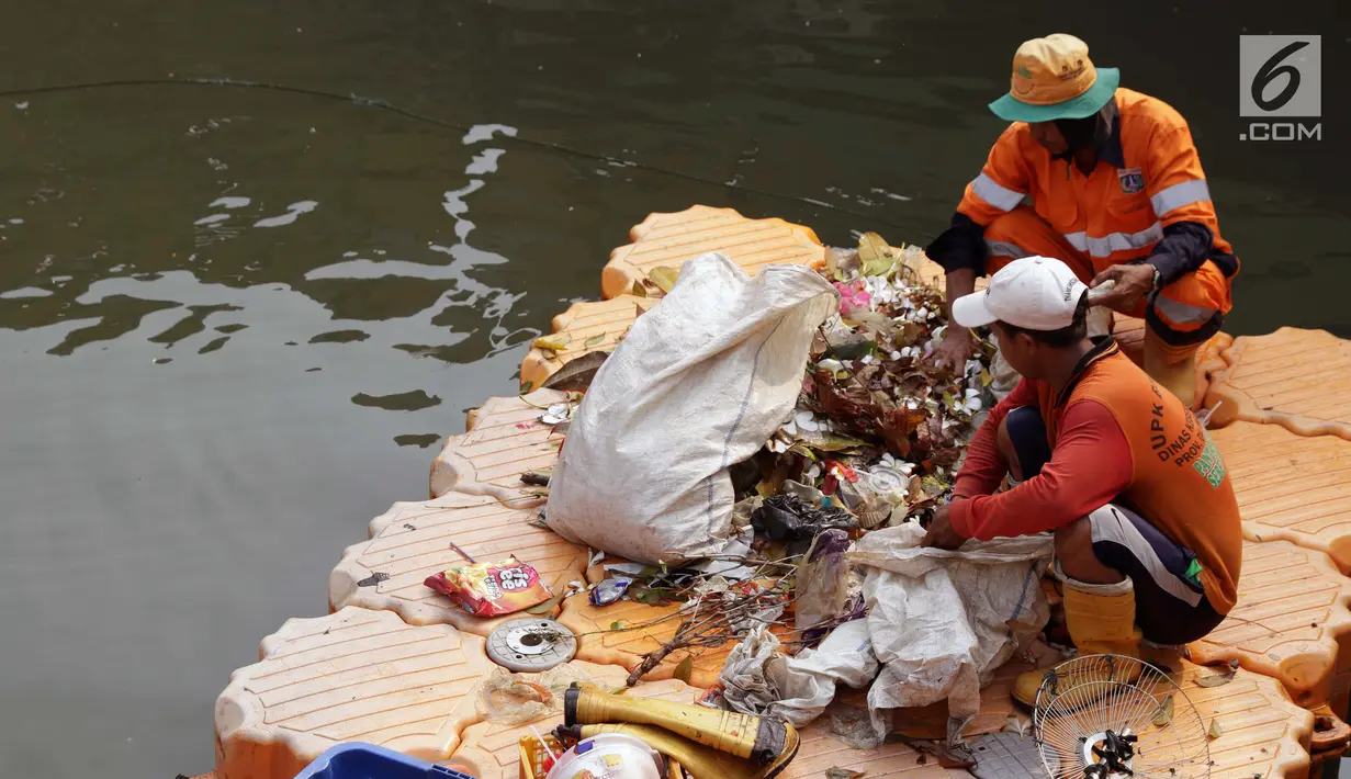 Petugas UPK Badan Air Pemprov DKI Jakarta membersihkan ceceran sampah di sepanjang Anak Sungai Ciliwung yang membelah kawasan Jalan Gajah Mada dan Hayam Wuruk, Selasa (9/7/2019). Pembersihan ini untuk menghindari penumpukan sampah dan memperlancar aliran air. (Liputan6.com/Helmi Fithriansyah)
