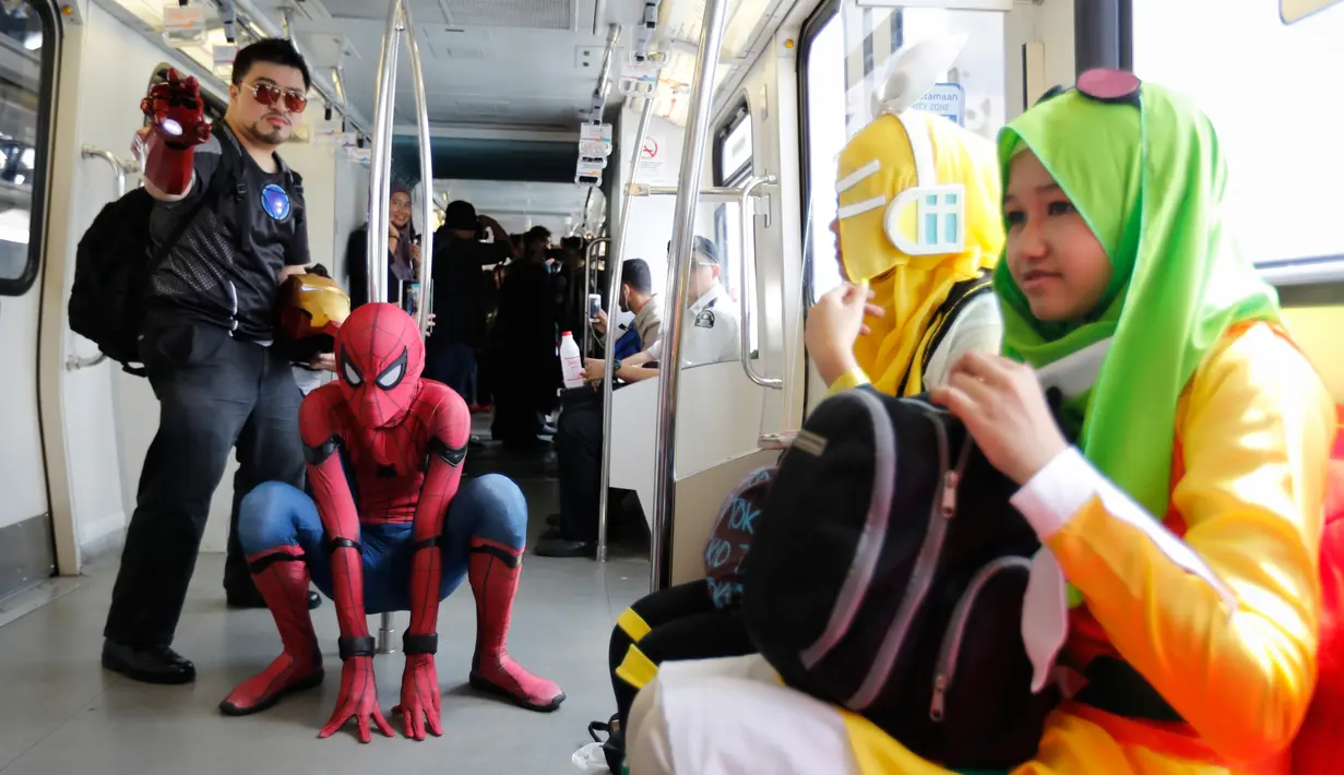 Cosplayer berkostum Spiderman dan Iron Man berpose sambil menaiki Light Rail Transit saat acara cosplay di Kuala Lumpur, Malaysia, Sabtu, 8 Juli 2017. Sejumlah tokoh karakter animasi tiba-tiba muncul di tengah-tengah ruang publik. (AP Photo/Vincent Thian)