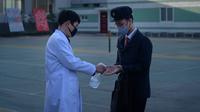 Petugas menyemprotkan cairan hand sanitizer kepada mahasiswa sebagai upaya mencegah penyebaran pandemi Covid-19 di Universitas Kedokteran Pyongyang, Rabu (22/4/2020). Korea Utara memberlakukan pembatasan ketat guna mengantisipasi penyebaran virus corona di negara tersebut. (KIM Won Jin/AFP)