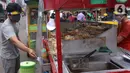 Pedagang mengenakan face sheild atau pelindung wajah saat berjualan di Tangerang, Banten, Rabu (13/5/2020). Penggunaan pelindung wajah tersebut dilakukan untuk mencegah risiko penularan virus corona COVID-19 pada saat berdagang. (Liputan6.com/Angga Yuniar)
