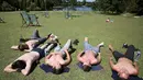 Sejumlah pria berjemur di Regents Park, London, Inggris, Selasa (19/7). Cuaca panas yang melanda Inggris dimanfaatkan warga untuk berjemur. (REUTERS/Neil Hall)