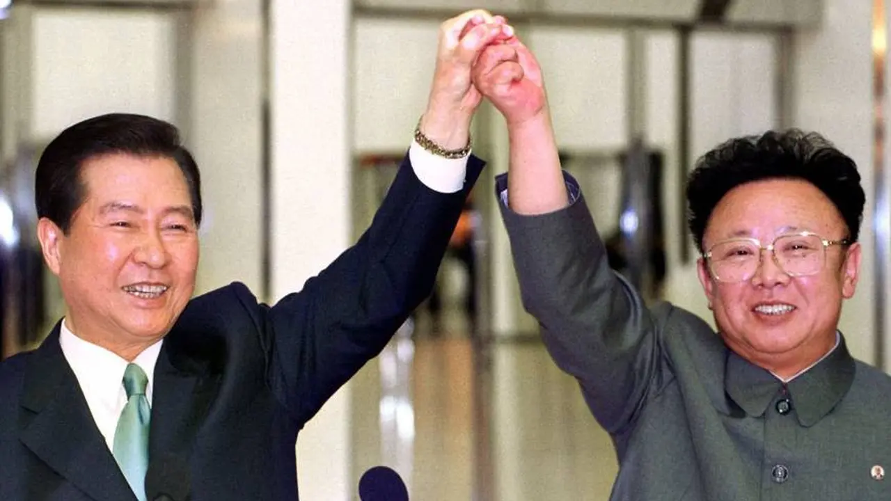 Presiden Korea Selatan, Kim Dae-jung dan pemimpin Korut Kim Jong-il berpegangan tangan sebelum menandatangani perjanjian di tengah pertemuan bersejarah antara dua Korea di Pyongyang pada 14 Juni 2000.
