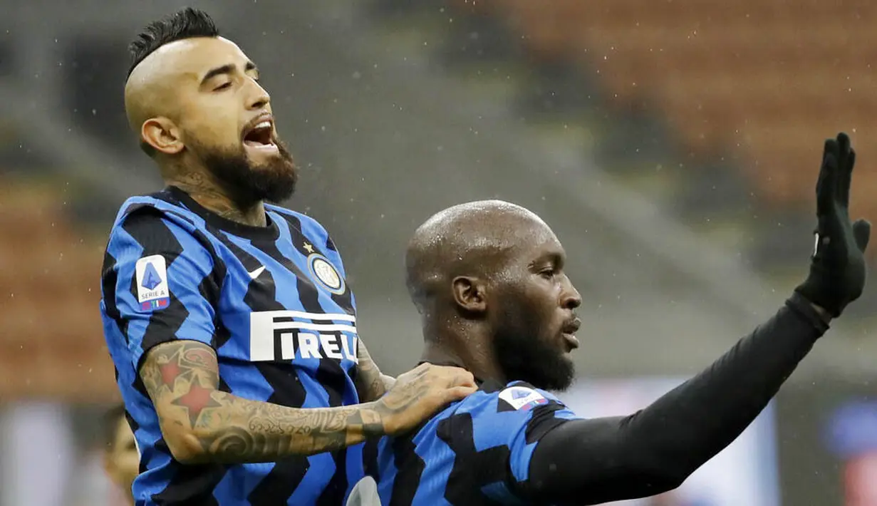 Striker Inter Milan, Romelu Lukaku, melakukan selebrasi bersama Arturo Vidal usai membobol gawang Spezia pada laga Liga Italia di Stadion Giuseppe Meazza, Minggu (20/12/2020). Inter Milan menang dengan skor 2-1. (AP/Luca Bruno)