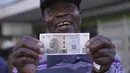 ZiG diperkenalkan secara elektronik pada awal April, namun masyarakat sekarang dapat menggunakan uang kertas dan koin. (AP Photo/Tsvangirayi Mukwazhi)
