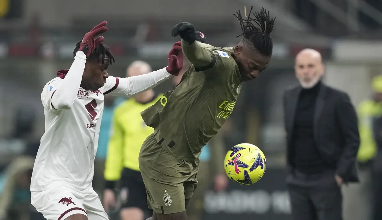 Bek AC Milan Theo Hernandez berebut bola dengan bek Torino Valentino Lazaro dalam duel pekan ke-22 Serie A 2022-2023, Sabtu (11/2/2023) dini hari WIB. Torino tertahan di urutan tujuh dengan 30 poin. 
(AP Photo/Antonio Calanni)