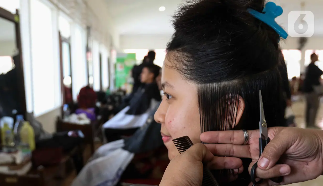 Pasukan Pengibar Bendera Pusaka (Paskibraka) melakukan prosesi potong rambut saat pemusatan diklat Paskibraka 2024 di Jakarta, Minggu (14/7/2024). (Liputan6.com/Herman Zakharia)