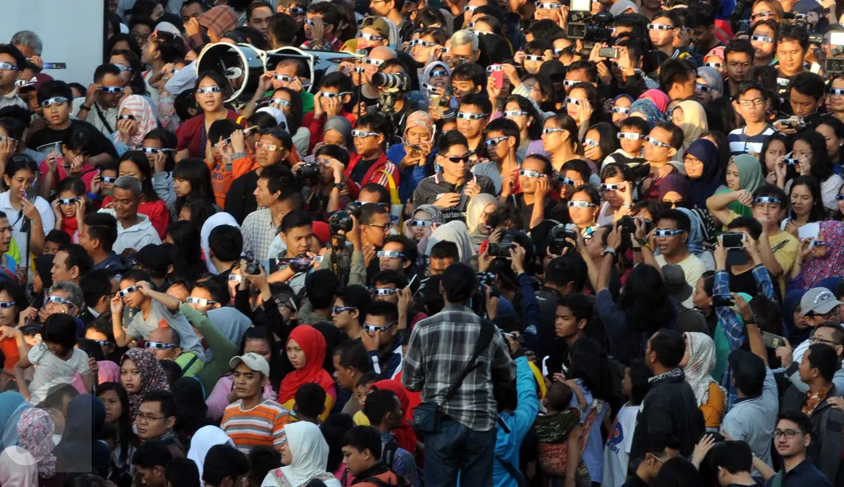 Warga menyaksikan Gerhana Matahari Total (GMT) di Planetarium, Jakarta, Rabu (9/3). Gerhana Matahari Total (GMT) di Jakarta terlihat sebagai gerhana matahari sebagian dengan ketertutupan 88,74 persen. (Liputan6.com/Helmi Afandi)