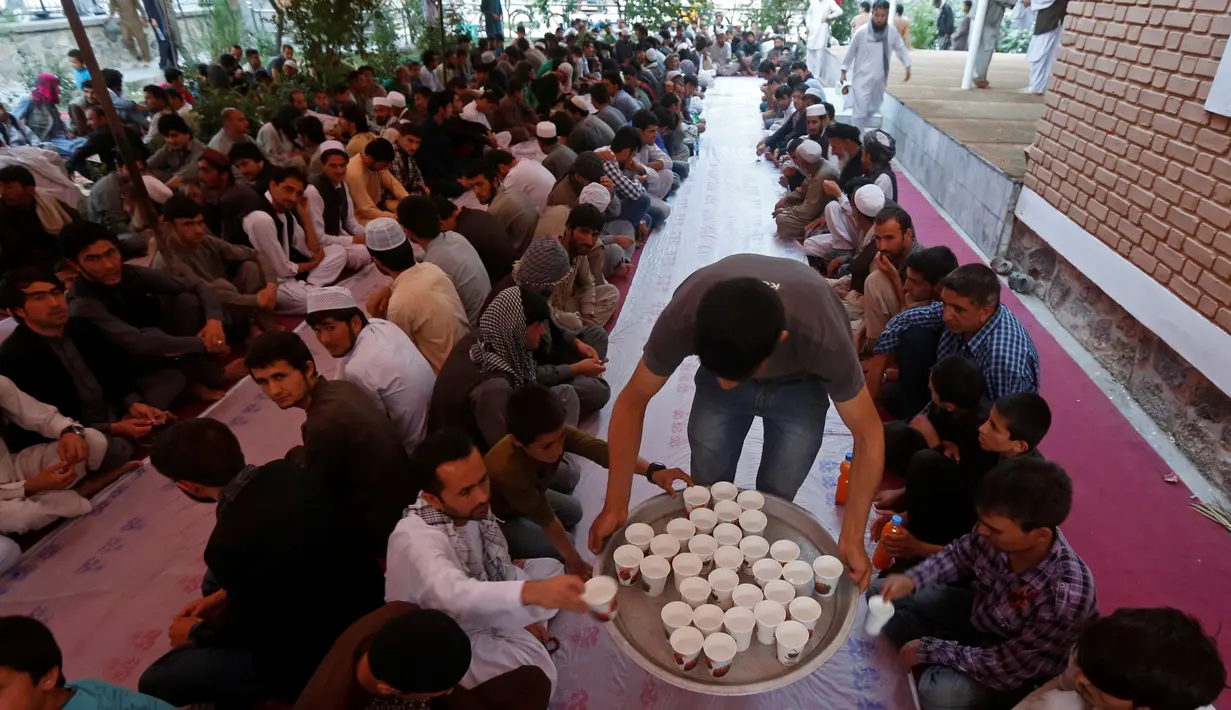 Panitia membagikan minuman untuk berbuka puasa di sebuah masjid di Kabul, Afganistan, 16 Juni 2016. Tradisi berbuka puasa bersama selama Ramadan merupakan momentum untuk mempererat tali persaudaraan. (REUTERS/Omar Sobhani)
