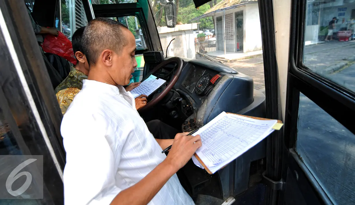 Petugas operator bus Transjakara memeriksa kilometer dan kondisi Bus Transjakarta di Koridor 6 Ragunan, Jakarta, Selasa, (30/6/2015). Bus yang melayani koridor tersebut terlihat banyak yang sudah tak layak jalan. (Liputan6.com/Yoppy Renato)