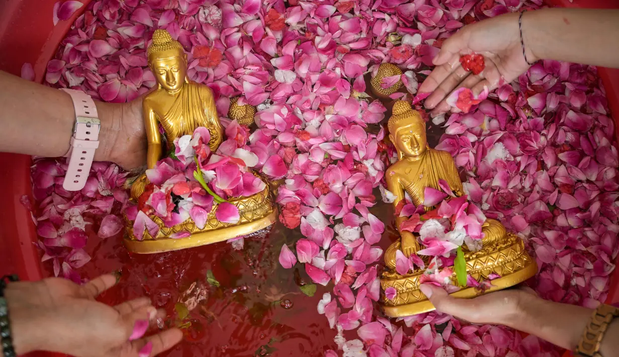 Warga membersihkan patung Buddha dalam persiapan perayaan Tahun Baru Imlek 2577 Kongzili di Vihara Buddhayana, Surabaya, Jawa Timur pada Senin 9 Februari 2026. Membersihkan patung Buddha merupakan ritual sakral tahunan yang dilakukan sebagai simbol penyucian diri dan penghormatan dalam menyambut Tahun Baru Imlek. (JUNI KRISWANTO/AFP)