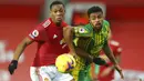 Penyerang Manchester United, Anthony Martial, berebut bola dengan pemain West Bromwich Albion, Darnell Furlong, pada laga Liga Inggris di Stadion Old Trafford, Minggu (22/11/2020). MU menang dengan skor 1-0. (Alex Livesey/Pool via AP)